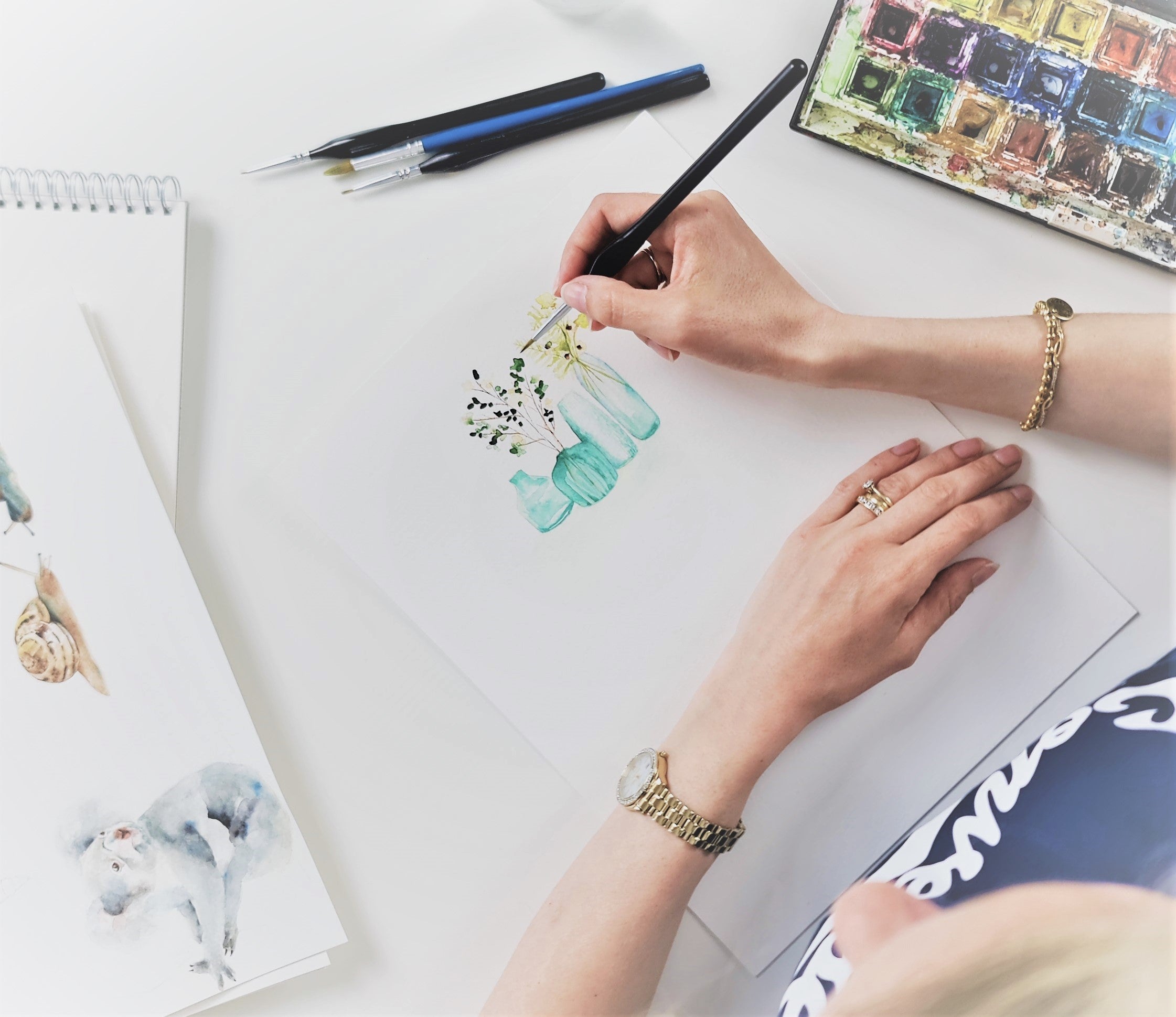 Annie Grant painting bottles and flowers for licensing 